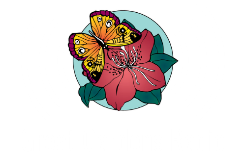 A butterfly with orange, yellow, and purple wings sits on a pink flower with green leaves, inside a blue circle.